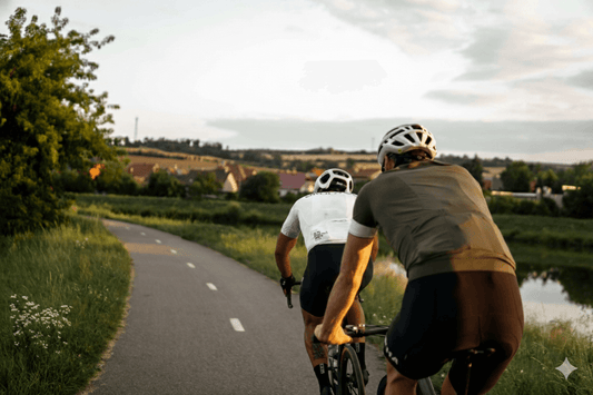 Two cyclists riding on a scenic path during sunset, illustrating a practical guide for using rear bike racks.